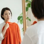 鏡の前で「あれ？」と首をかしげる女性