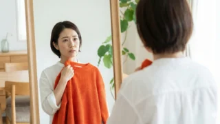 鏡の前で「あれ？」と首をかしげる女性